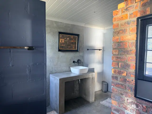 Bathroom, with a basin set on concrete and brick